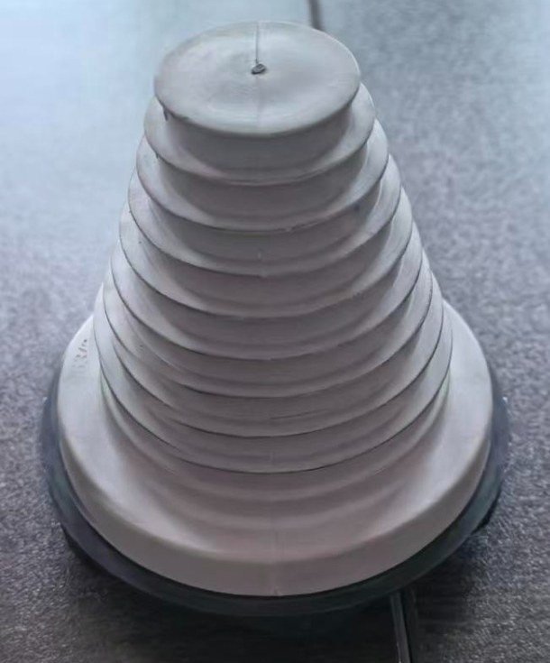 Large-cable stepped transit grommet — moulded TPV on a flange base, cone knife-trimmed to the cable OD (M63+ / heavy-gauge cable). M&J production sample.
